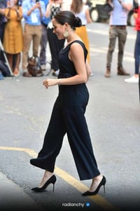 a woman in a black dress and heels