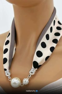 a woman wearing a polka dot dot scarf around a neck