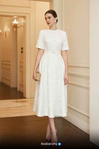 a woman in a white dress with a purse