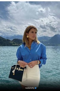 a woman in a blue shirt and white skirt