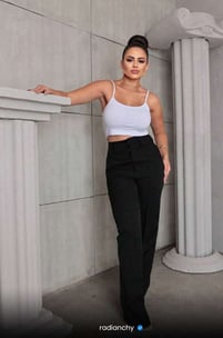 a woman in a white crop top and black pants
