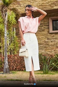 a woman in a pink shirt and white skirt