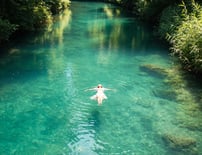 Person by tranquil water, representing peaceful and lasting transformation