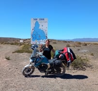 a woman standing next to a motorcycle with a map of the world