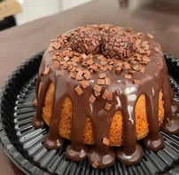 Delicioso bolo de chocolate com cobertura de ganache, decorado com granulado e bombons, perfeito par