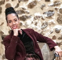 a woman in a red jacket and plaid skirt