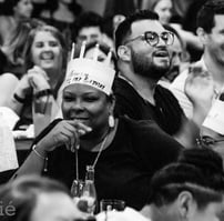 black woman in show audience with birthday crown smiling