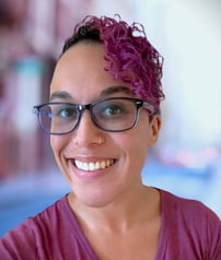 a woman with glasses and a purple shirt