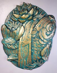 A plaque in the style of traditional tattoo art. it shows a Koi fish surrounded by waves and a lotus