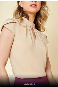 a woman in a beige top with a purple skirt