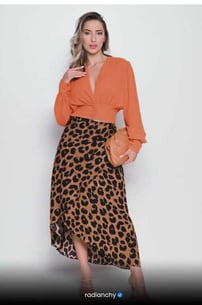 a woman in a leopard print skirt and orange shirt