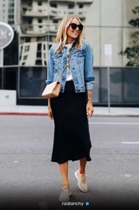a woman in a black skirt and denim jacket
