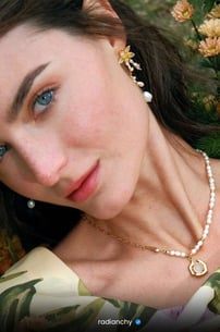 a woman with a pearl necklace and pearl earrings