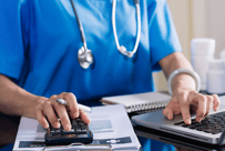 a nurse in scrub scrubs and a stethoscope on a laptop