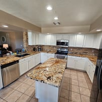 Freshly refinished white kitchen cabinets with a smooth, professional finish, enhancing the space with a clean and modern loo