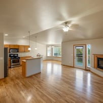Professional photograph of a clean and newly design home living room and kitchen.