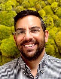 a man with a beard and glasses on a green background