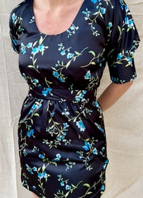 The front of a black satin cocktail dress with blue printed flowers