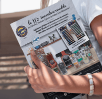Un magazine tenue en main par une femme, on peut y voir une parution publicitaire.