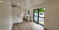 View of kitchen cupboard and sliding door of tiny home