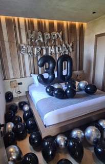 Glamorous 30th birthday room design featuring black and silver balloons and luxury decor.