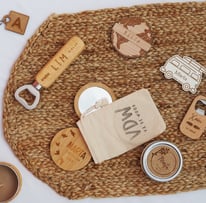 a table with a bag of personalized wood items and a bottle opener