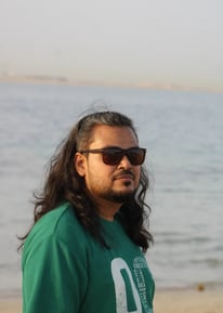 ध्यानपूर्ण मुद्रा में समुद्र की ओर देखते हुए एक व्यक्ति – आत्म-चिंतन और शांति की झलक