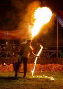 giocoliere che pratica l'arte dello sputafuoco