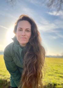 a woman with long hair and a green jacket