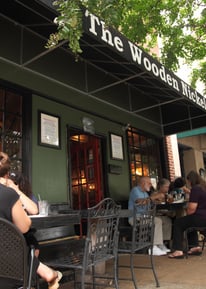 a group of people sitting at tables outside a restaurant