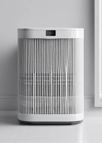 A rectangular air filter is held in a person's hand. The filter has visible white pleats and is encased in a black frame. It appears to be new or unused. The background includes a wooden floor and part of a device or machine.