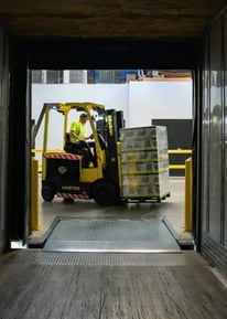 Forklift operator loading pallet into truck at warehouse — efficient delivery and logistics handling