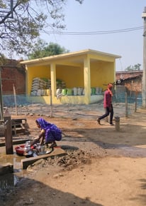 Woman washing utensils front of chabutra