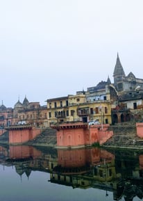 a river with a bridge and buildings in the background