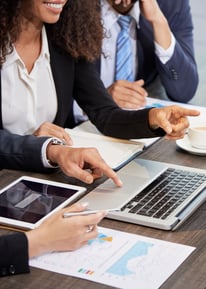 Pessoas em reunião frente a um notebook
