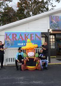 Miembros del equipo de Kraken Mar y Tierra frente a la entrada del restaurante en Fountain Inn