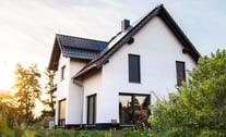 Ein Haus mit einem Dach aus Solarpaneelen und einem zusätzlichen Solarpanel daneben.