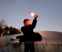 niño sosteniendo linterna en un bote durante el atardecer