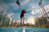 a man is jumping in the air with a tennis racket