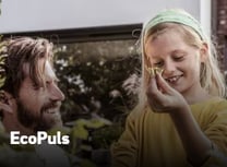 a man and a woman are smiling and holding a plant
