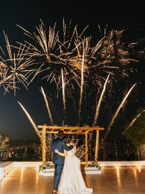 Golden fireworks lighting up a Santorini evening wedding reception.