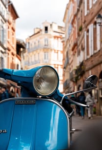 a blue scooter parked on a city street