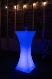 Glowing blue cocktail table in the backyard of an event in Redlands.