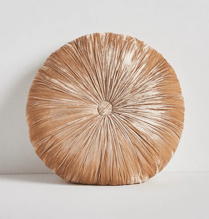 a beige round velvet pillow