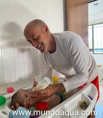 a man is feeding a baby in a high chair