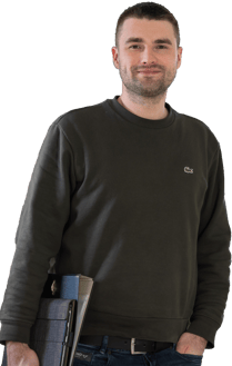 Ein Energieberater/Energieeffiziensexpert in einem schwarzen Hemd und Jeans, der ein Notizbuch hält.