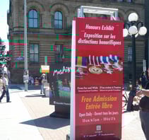 a man standing in front of a sign for a free exhibit