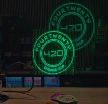 Interior de Fourtwenty 420 Cannabis Club con letreros LED verdes