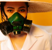 a woman in a white shirt and hat with a green mask