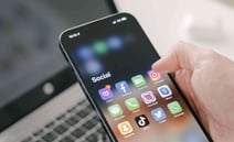 Eine Person, die ein Handy in der Hand hält, ein Symbol zur Kontaktaufnahme.